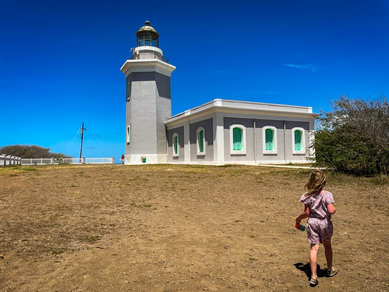 A young girl walks toward a lighthouse at Cabo Rojo National Wildlife Refuge. Rojo National