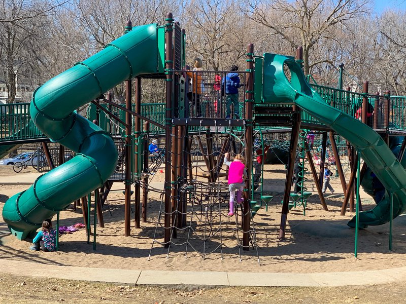 A young girl climbs a ladder within the playground at Lake Harriet.